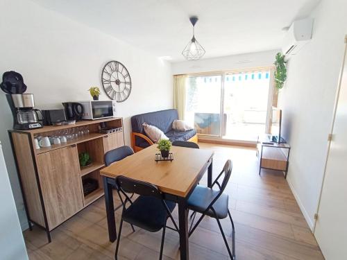 un salon avec une table de salle à manger et une cuisine dans l'établissement Climatisation, Grande Terrasse, Parking privé, au Barcarès