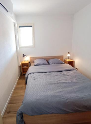 une chambre avec un grand lit et une fenêtre dans l'établissement Climatisation, Grande Terrasse, Parking privé, au Barcarès