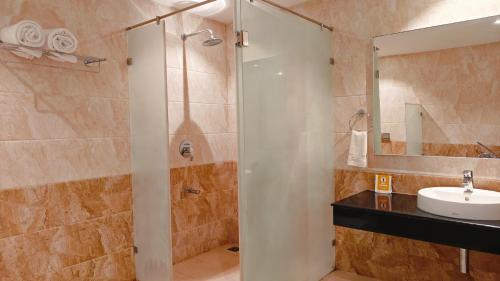 a bathroom with a shower and a sink at MM Legacy - A Bergamont Hotel, Kanchipuram in Kanchipuram