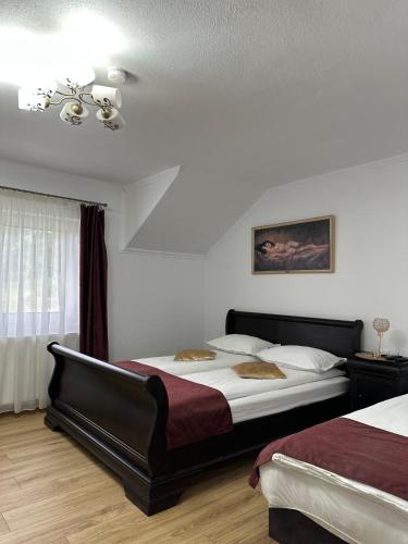 a bedroom with two beds and a chandelier at Vila Miorita in Sebeş