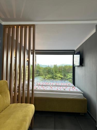 a bedroom with a bed and a large window at Vila Miorita in Sebeş