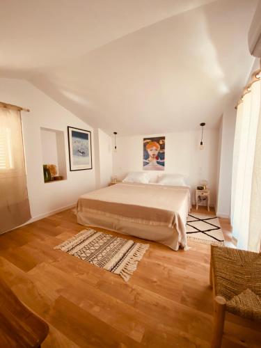 une chambre avec un grand lit et un parquet dans l'établissement Mas Gomez Bolfa, à Bouleternère