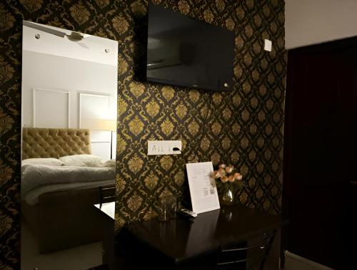 a room with a bed and a table with a mirror at The First Floor I Top Rated Boutique Homestay I Near Lekhraj Metro Lucknow in Lucknow