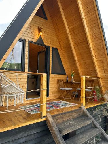 a cabin with a porch with a table and chairs at Vila Miorita in Sebeş