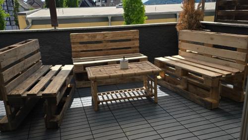 two wooden benches and a table with a candle on it at work & stay house in Linz in Linz am Rhein
