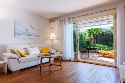un salon avec un canapé blanc et une table dans l'établissement Garden-level apartment inside upscale district, à Cannes