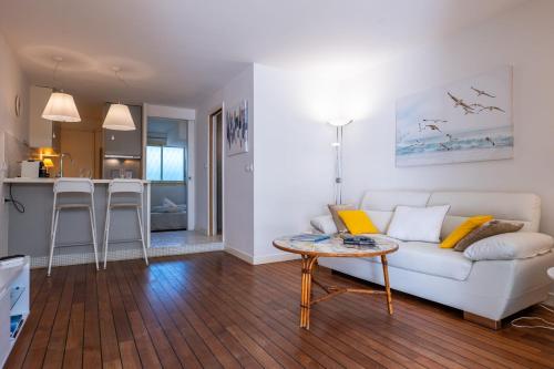 un salon avec un canapé blanc et une table dans l'établissement Garden-level apartment inside upscale district, à Cannes