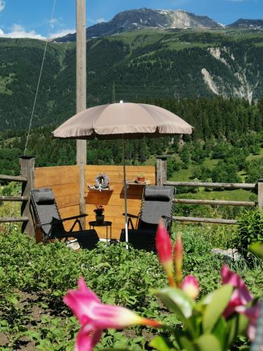 a table and chairs under an umbrella in the mountains at Hockmatte in Grengiols