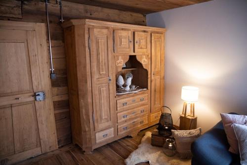 a room with a large wooden cabinet with vases in it at Hockmatte in Grengiols