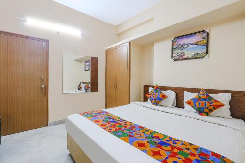 a bedroom with a king sized bed with a colorful blanket at Hotel Prestige Castle - Nr KIMS Hospital, Kondapur in Hyderabad