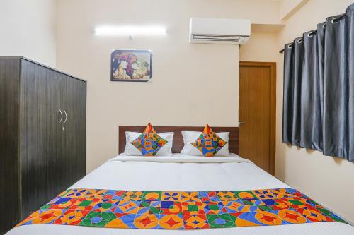 a bedroom with a large bed with a colorful blanket at Hotel Prestige Castle - Nr KIMS Hospital, Kondapur in Hyderabad