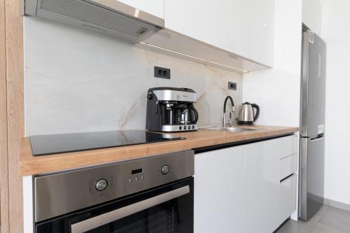 a kitchen with a stove and a microwave at Chryselia Suites- Private Pool in Keratokampos