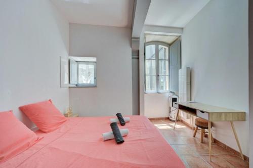 - une chambre avec un lit rose et un bureau dans l'établissement Appartement avec terrasse, à Arles