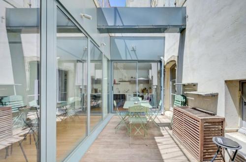 d'une terrasse avec des portes en verre, une table et des chaises. dans l'établissement Appartement avec terrasse, à Arles