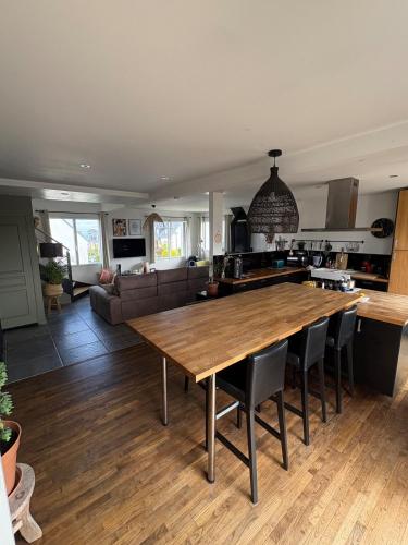 Il comprend une cuisine et un salon avec une grande table en bois. dans l'établissement Charmante Maison Néo-bretonne, à Perros-Guirec