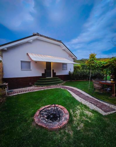 a house with a fire pit in the yard at Bambuus Garden & Spa in Drăgăşani