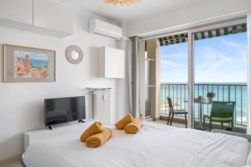 - une chambre avec un lit, une télévision et un balcon dans l'établissement Rives d'or 2, Beautiful beachfront studio, beach access, AC, à Roquebrune-Cap-Martin