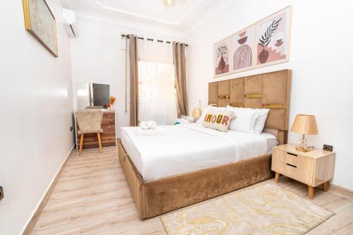 a bedroom with a large bed and a desk at Appartement Ensolleillé Au coeur De Tanger in Tangier