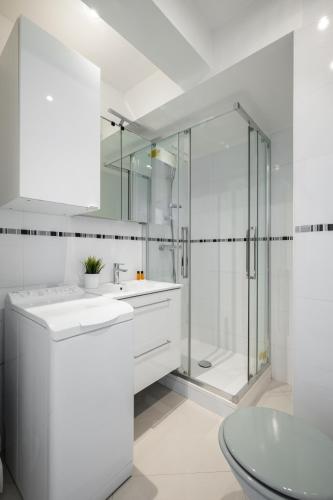 une salle de bain blanche avec une douche et un lavabo dans l'établissement Rives d'or 2, Beautiful beachfront studio, beach access, AC, à Roquebrune-Cap-Martin