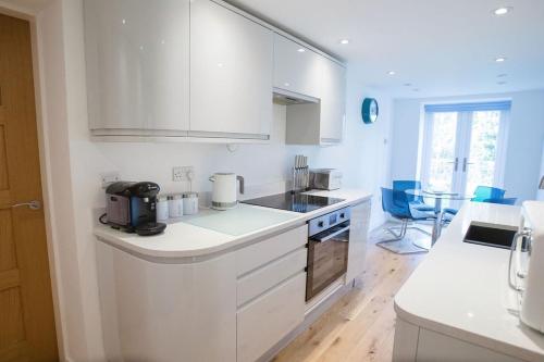 a kitchen with white cabinets and a counter top at Superb 2 bedroom town apartment, quiet location in Harrogate