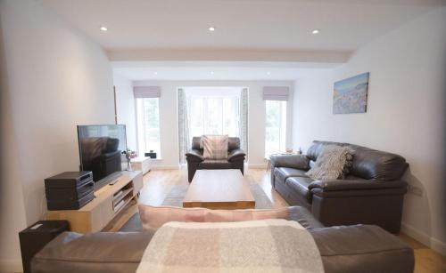 a living room with a couch and a tv at Superb 2 bedroom town apartment, quiet location in Harrogate
