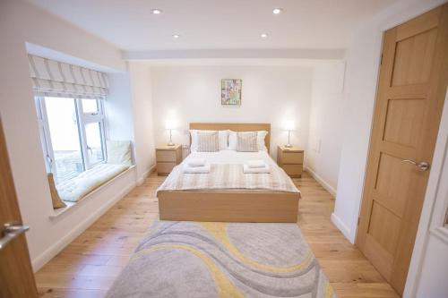 a bedroom with a large bed and two windows at Superb 2 bedroom town apartment, quiet location in Harrogate