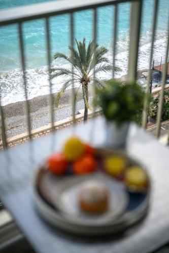 - une assiette de nourriture sur une table avec vue sur la plage dans l'établissement Rives d'or 2, Beautiful beachfront studio, beach access, AC, à Roquebrune-Cap-Martin