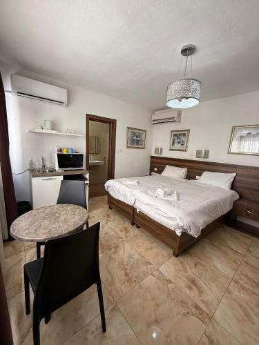 a bedroom with a bed and a table and a kitchen at Slimiza Suites in Sliema