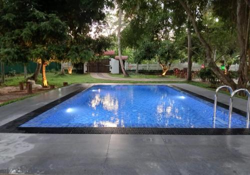 a pool with blue water in a yard at VinSri Villa in Kurunegala