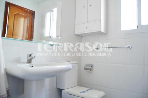 a white bathroom with a sink and a toilet at Terrasol Azucarera Atico H in Torre del Mar