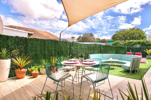 a patio with a table and chairs and a fence at CASA MIMAR moderna y acogedora in La Oliva