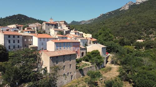 a group of buildings on a hill with trees at CROUXETO Chambres d'hôte in Duilhac