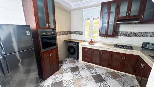 a kitchen with a stainless steel refrigerator and a dishwasher at Sunset Villa by the Ocean in Ibekhchach