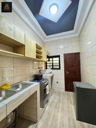 a large kitchen with a sink and a stove at SMART BÂTIPRO Appartement 2 chambres salon 2 in Cotonou