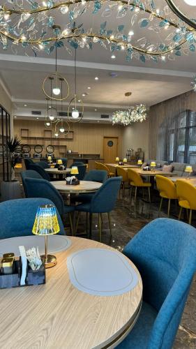 un ristorante con sedie e tavoli blu e una tavola di Ozen Palace Hotel a Almaty