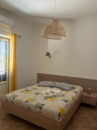 a bedroom with a bed and a lamp and a ceiling at Monte do Carapetal in Amareleja