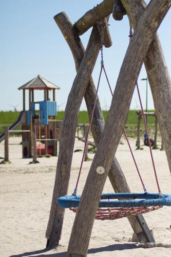 an empty swing set at a playground at Urlaub an der Nordsee - NEUE Penthouse-Ferienwohnung Deichliebe, direkt hinterm Deich in Butjadingen