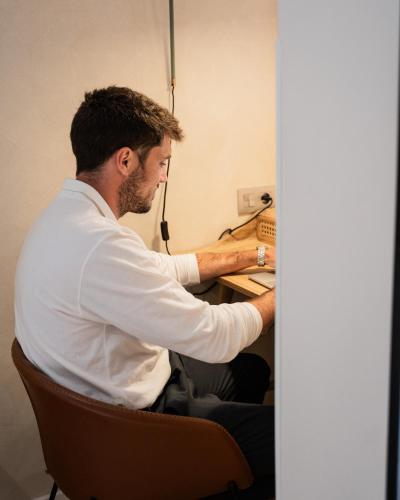 a man sitting at a desk working at a computer at Chez Abel in Las Palmas de Gran Canaria