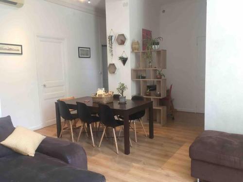 un salon avec une table, des chaises et un canapé dans l'établissement Appartement en rez de jardin centre ville, à La Celle-sous-Gouzon
