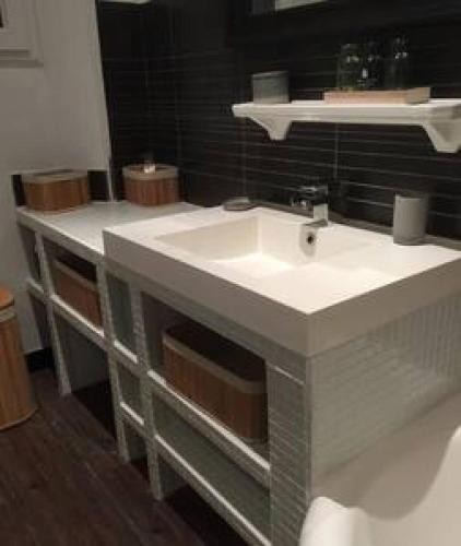 une salle de bain avec un lavabo blanc et un miroir dans l'établissement Appartement en rez de jardin centre ville, à La Celle-sous-Gouzon