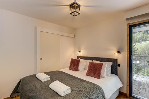 une chambre avec un grand lit et une fenêtre dans l'établissement Mazot de Kayla, Alpes Travel, Les Houches, Sleeps 4, aux Houches