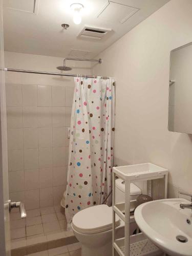a bathroom with a toilet and a shower curtain at The Intramuros Suite in Manila