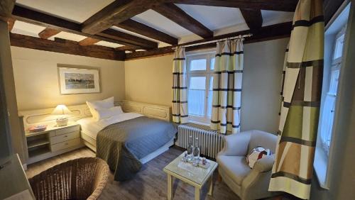 a bedroom with a bed and a chair and a table at Altes Pfarrhaus Hotel und Restaurant in Bad Überkingen