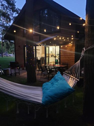 a hammock in front of a house at night at Domek pod sosnami in Ełk