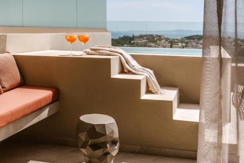 two glasses of wine sitting on a stair in a balcony at Sivota Sun Side Serenity in Sivota