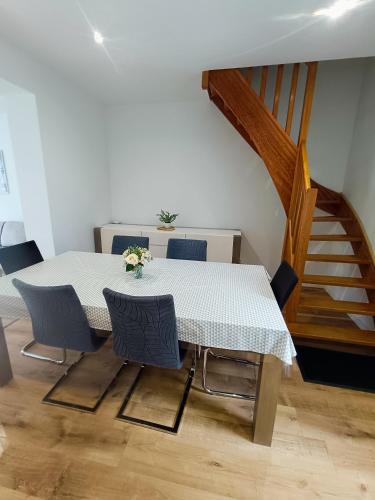 une table et des chaises dans une pièce avec un escalier dans l'établissement A 1min a pied de la plage Petit fort Philippe, à Gravelines