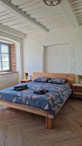 a large bed in a room with two tables at Vārves Muiža in Vārve
