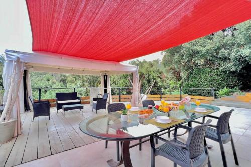 un patio avec une table et des chaises et un plafond rouge dans l'établissement Villa La Dauphine, à Fréjus