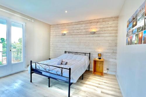 une chambre avec un lit et une grande fenêtre dans l'établissement Villa La Dauphine, à Fréjus