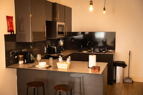 a kitchen with a counter with two stools and a counter top at Chic Brighton Studio in Brighton & Hove